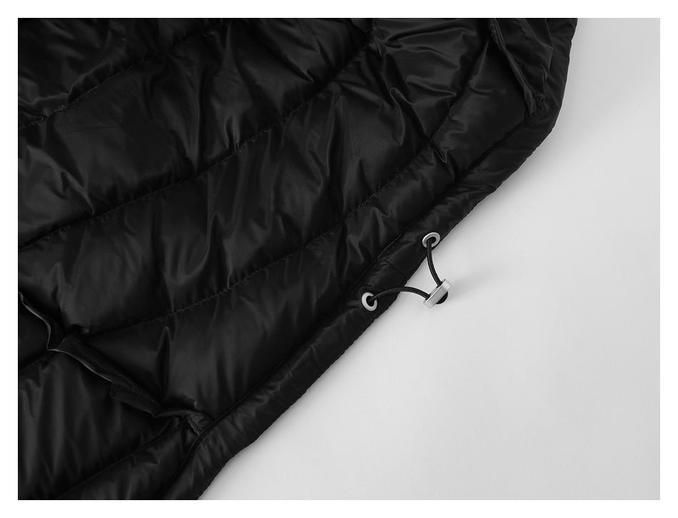 Close-up of black quilted garment hem with an adjustable cord, metal eyelets and toggle.