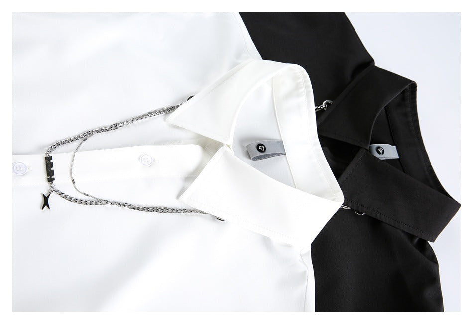Close-up of white and black shirt collars with silver chain accessories and small collar tabs.