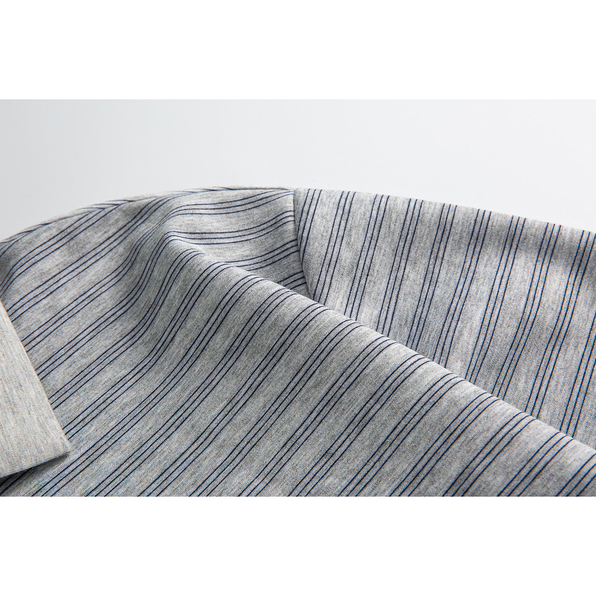 Close-up of fine dark stripes across the light gray polo fabric and a garment seam.