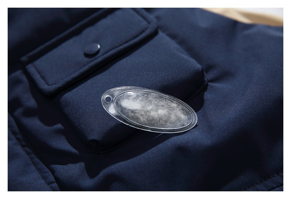 Close-up of a navy garment pocket with a snap flap and an oval clear insert showing white fibers.