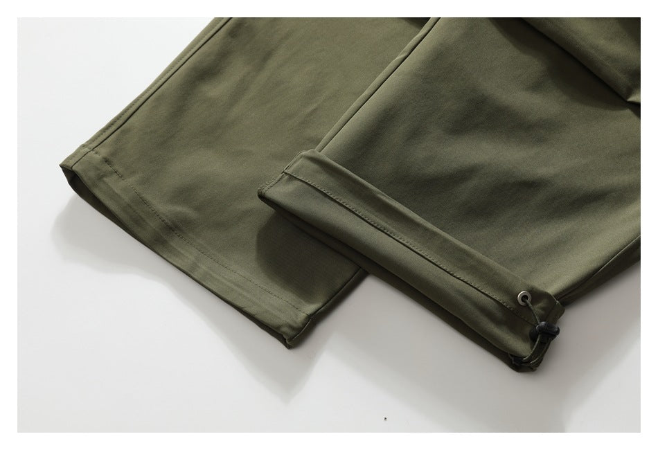 Close-up of olive-green trouser hems, including a cuff with an adjustable drawcord.