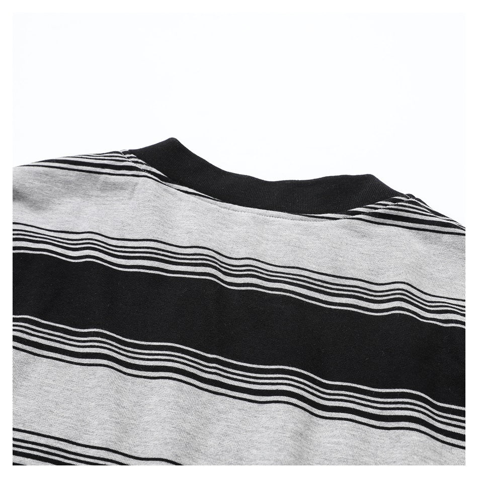 Close-up of a black crew neckline on a black and heather-gray striped top.