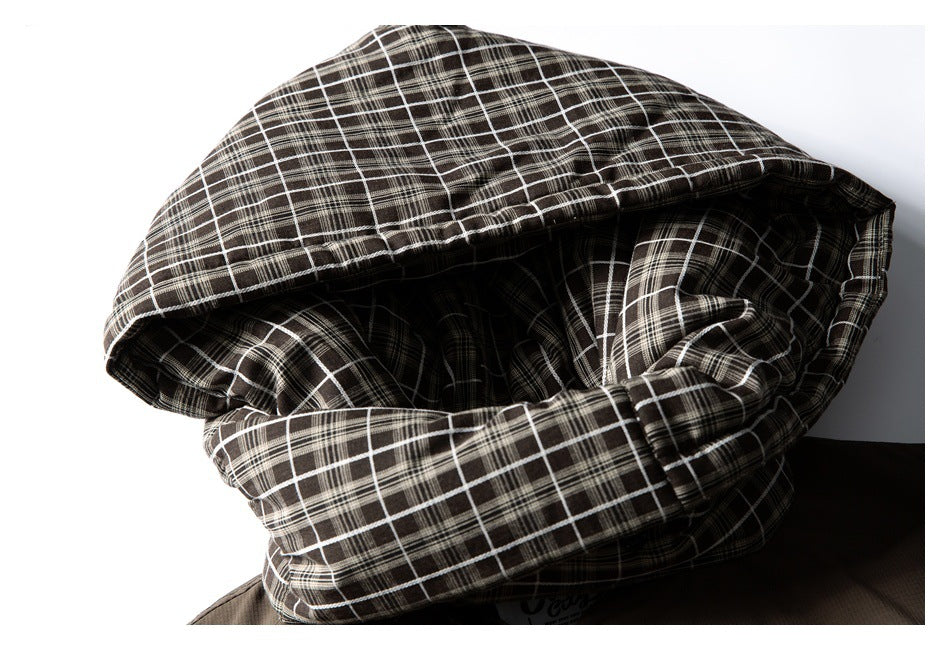 Close-up of a dark brown jacket hood lined with black-and-white plaid fabric.