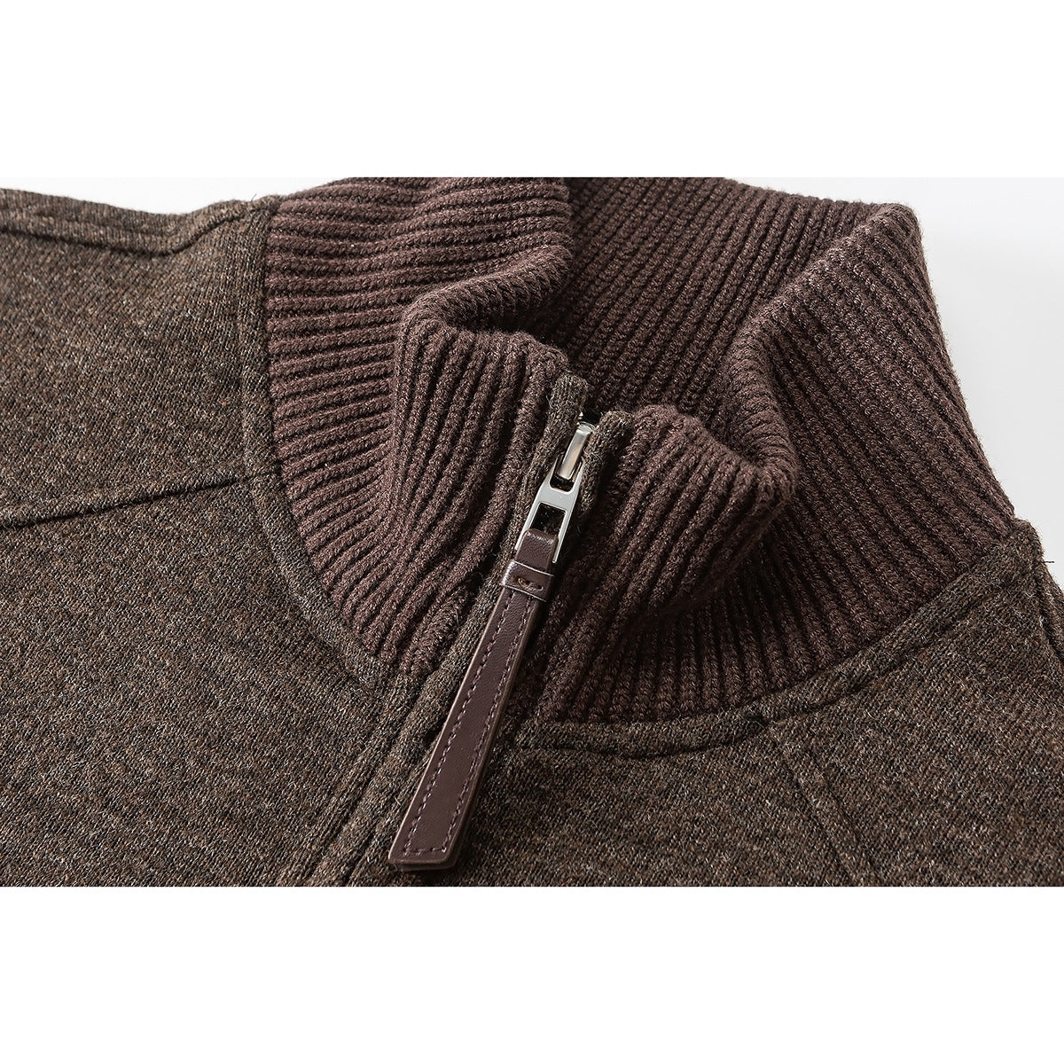 Close-up of a brown quarter-zip sweater’s ribbed collar and zipper with a leather pull tab.
