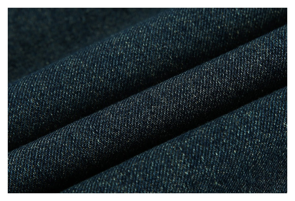 Close-up of dark indigo denim folded to show its woven texture.