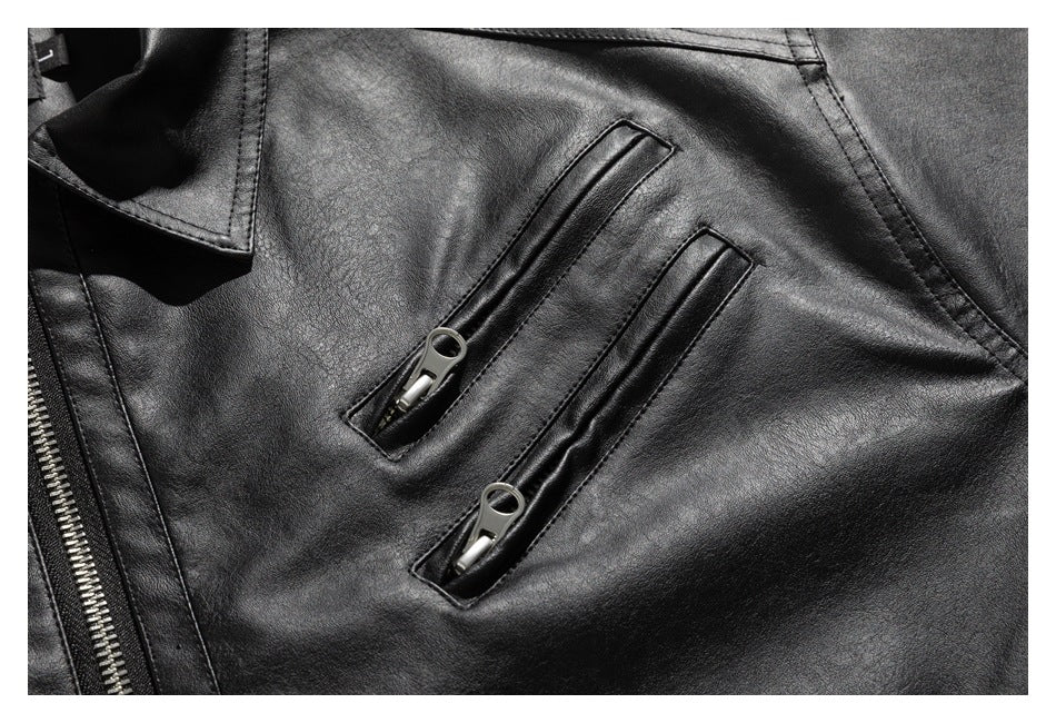 Close-up of two narrow vertical zip pockets and part of the front zipper on a black jacket.