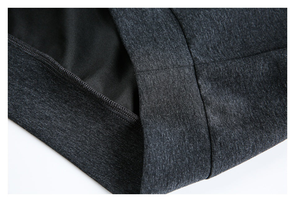 Inside close-up of a charcoal heather garment showing an overlocked seam and folded edge.
