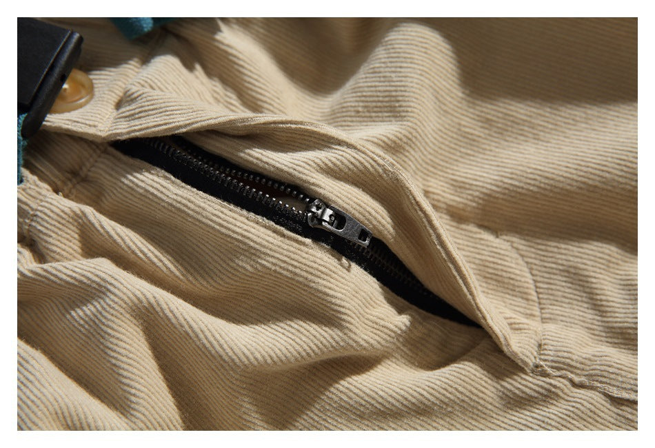 Close-up of a black zipper on beige ribbed corduroy fabric.