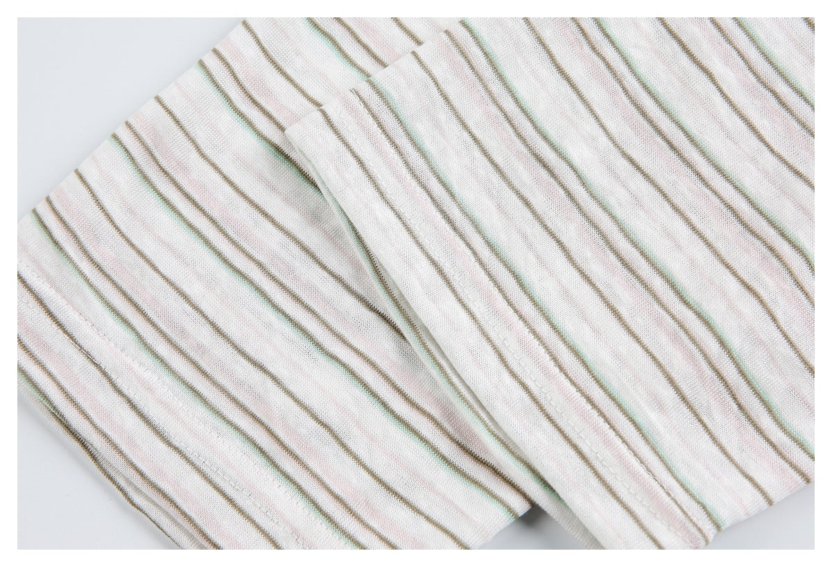 Close-up of a folded, stitched edge on off-white knit with narrow taupe, pale pink, and mint stripes.