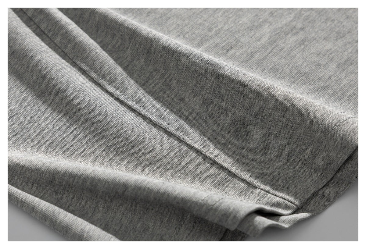 Close-up of a stitched seam and hem on gray knit fabric.