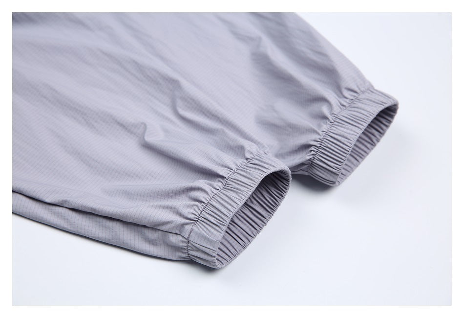 Close-up of two gathered elastic openings on a light gray pinstriped garment.