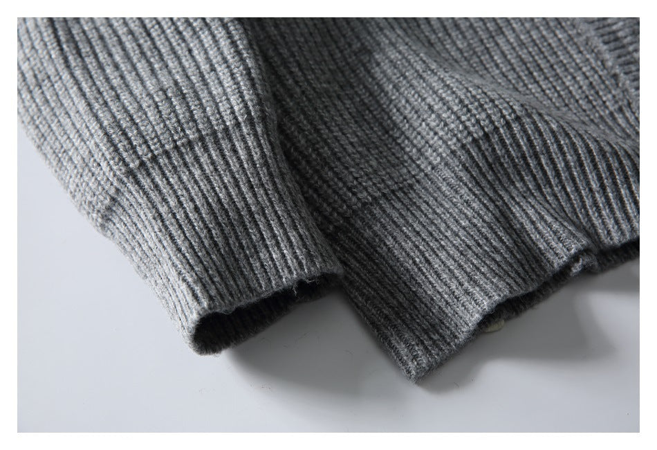 Close-up of gray rib-knit sweater fabric and a ribbed cuff or hem edge.
