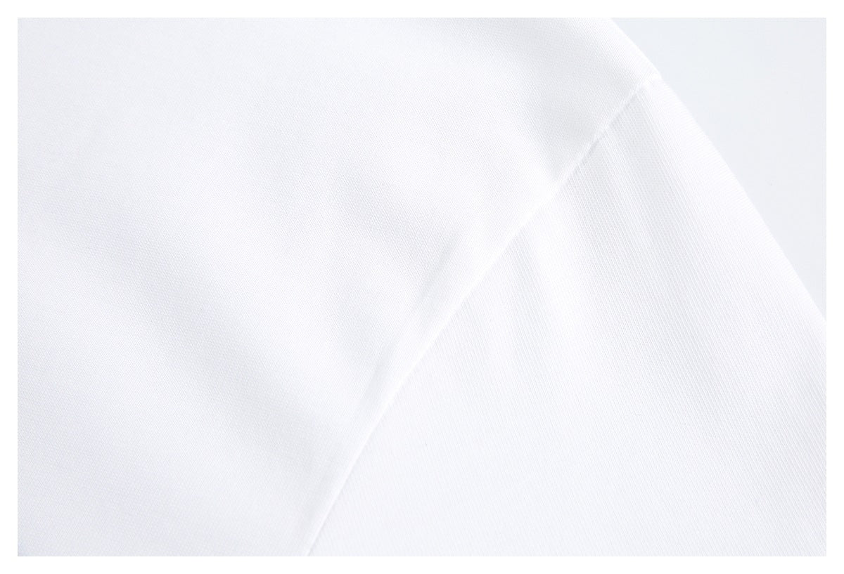 Close-up of a white shirt's shoulder seam and sleeve fabric.