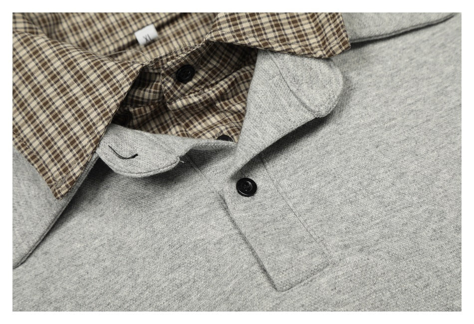 Close-up of a heather-gray sweatshirt neckline with a brown plaid collar insert and black buttons.