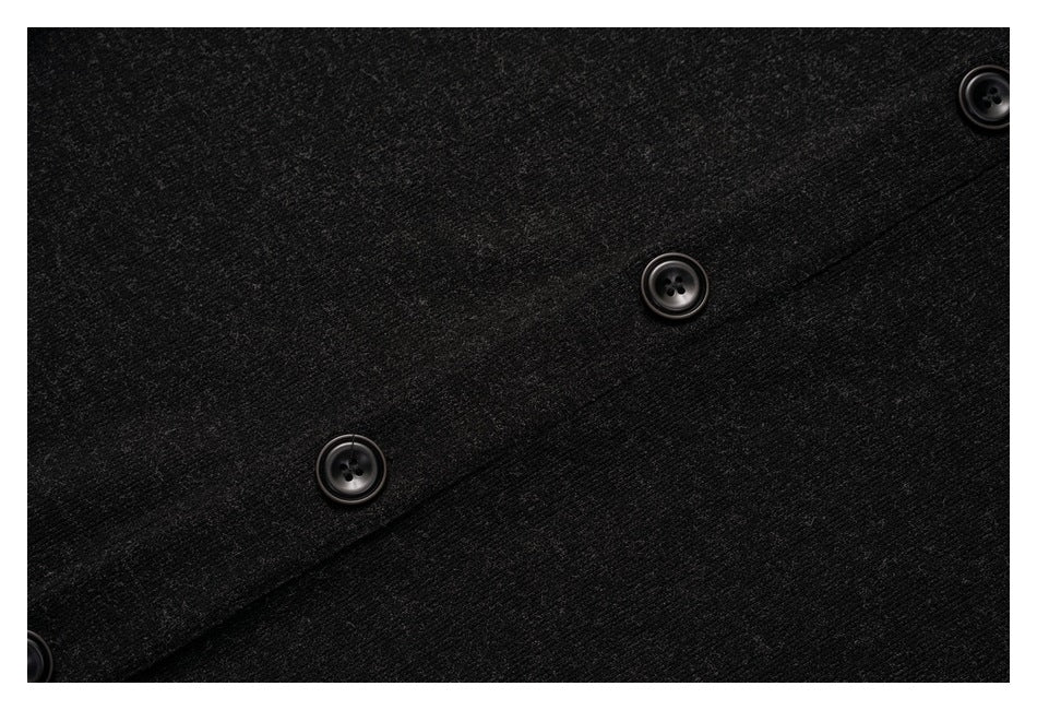 Close-up of charcoal-black fabric with a diagonal button placket and several black buttons.