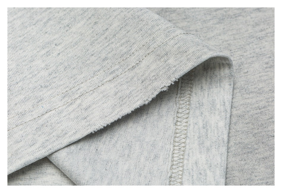 Close-up of the T-shirt's folded hem and visible overlocked seam stitching.