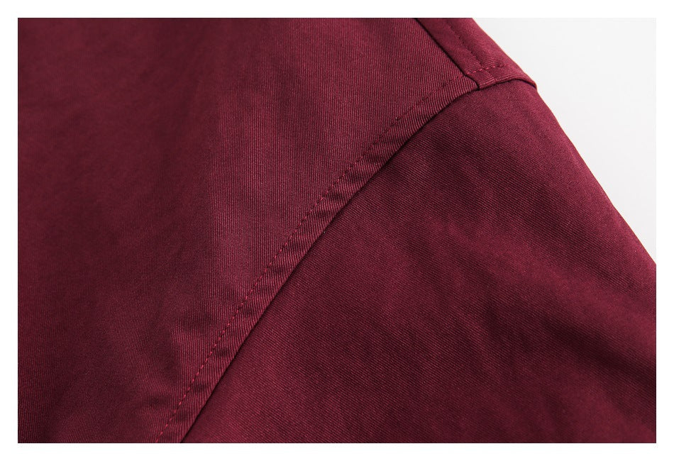 Close-up of a burgundy jacket's shoulder seam and sleeve.