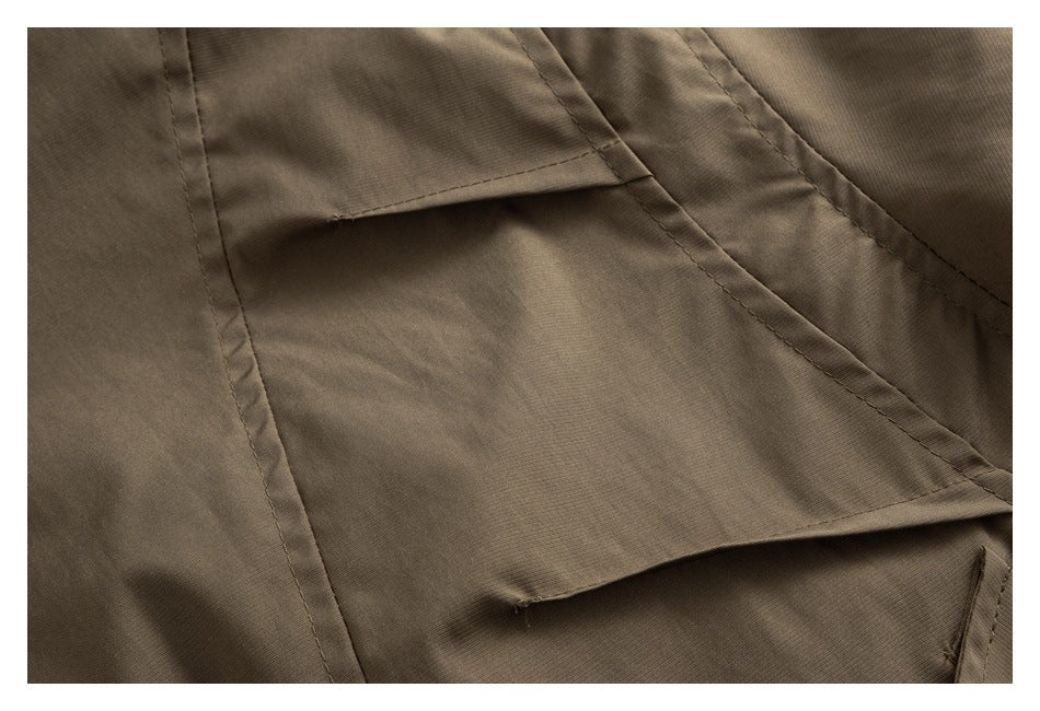 Close-up of a brown jacket seam and overlapping fabric panel.