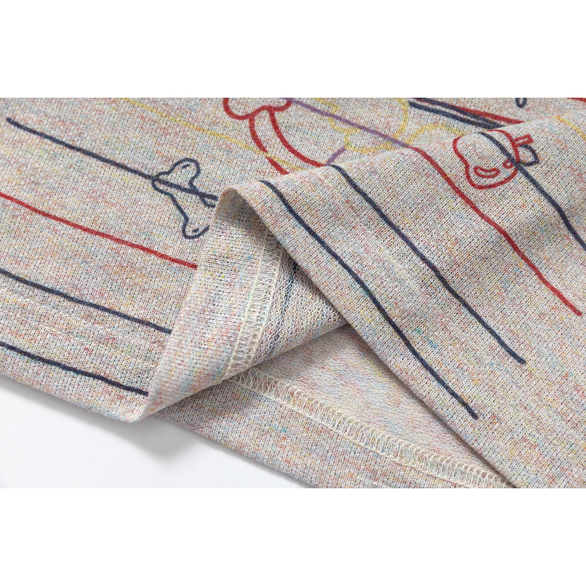 Close-up of the printed fabric and folded seam on a light gray speckled top.