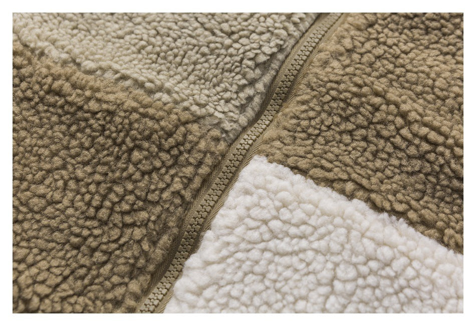 Close-up of a diagonal zipper seam between taupe-brown and cream looped fleece panels.