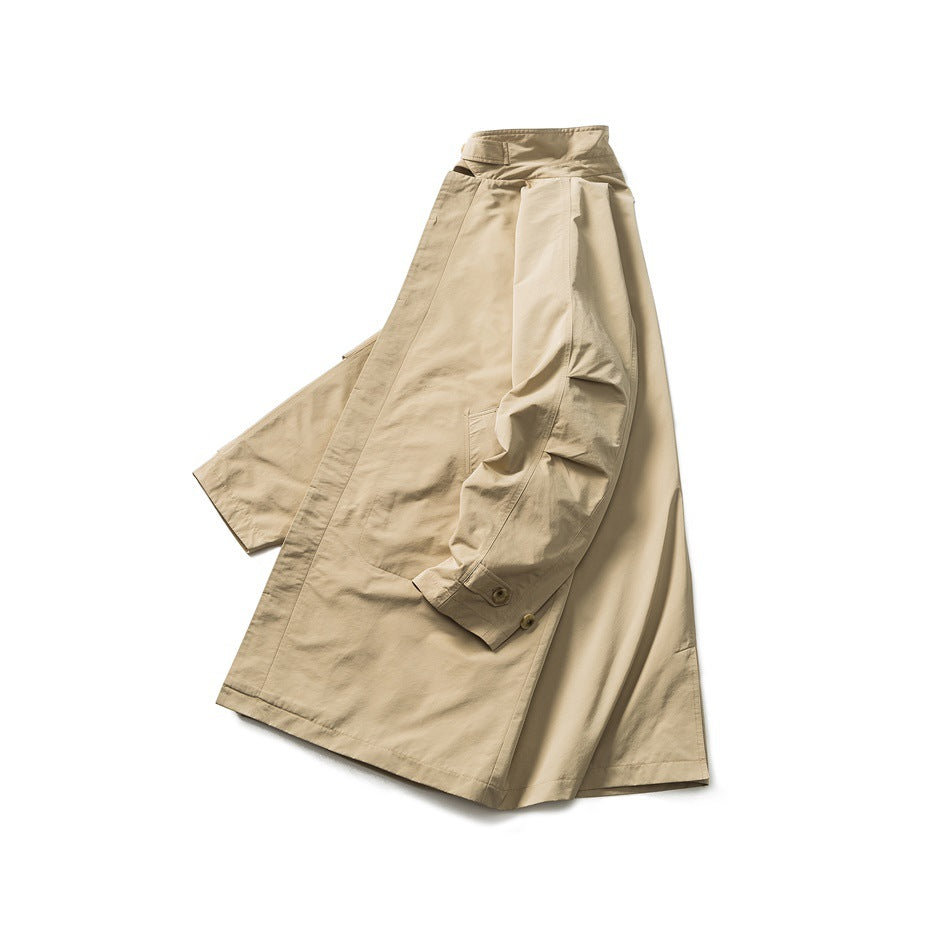 Tan long coat laid out at an angle, showing its high collar, buttoned cuffs, and wide sleeves.