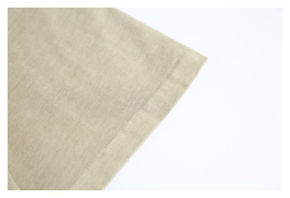Close-up of the beige T-shirt's short sleeve and double-stitched hem.