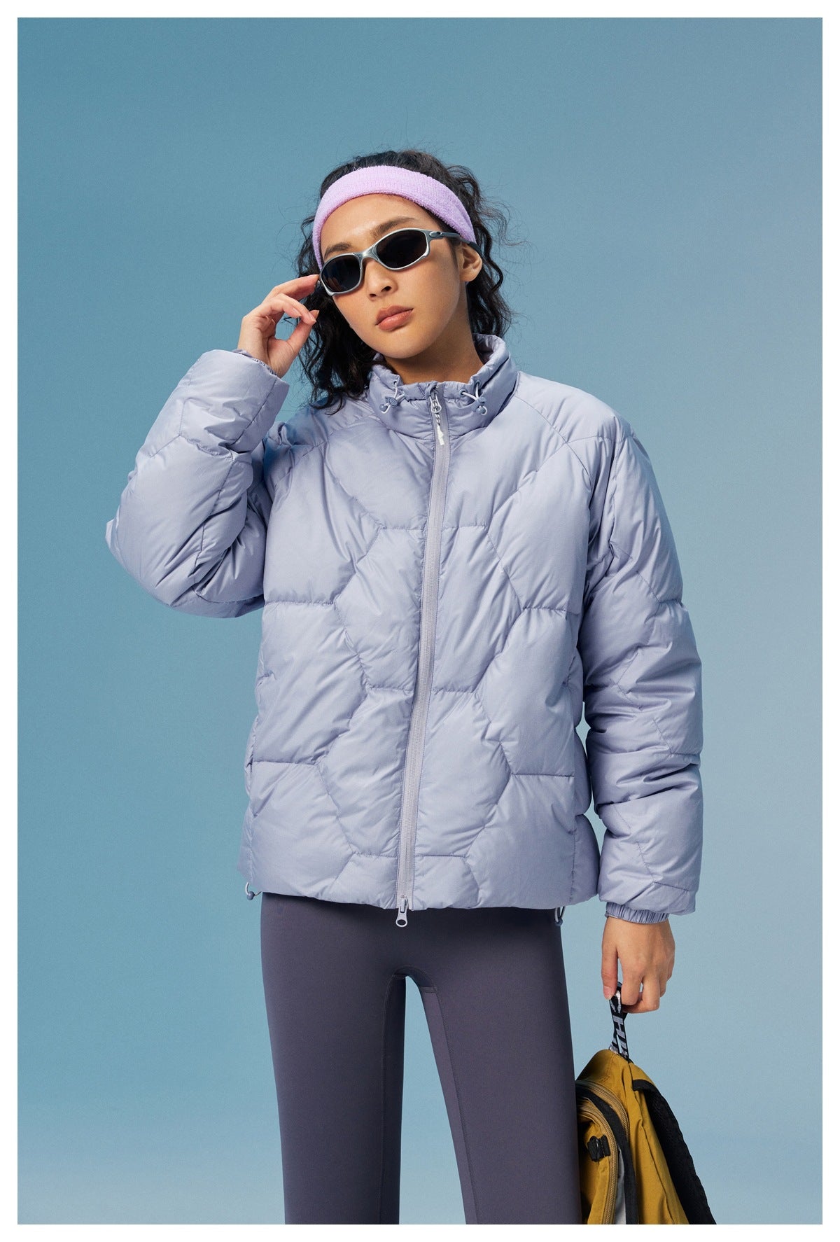 Front view of a model wearing a lavender-gray quilted jacket with a high collar, zip closure, and full sleeves.