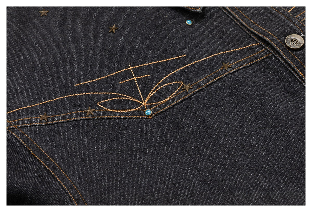 Close-up of bronze floral stitching, star studs, and turquoise accents on charcoal denim.