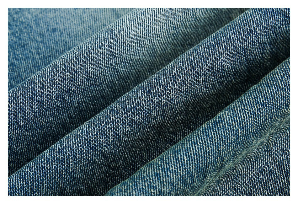 Close-up of blue denim fabric with a diagonal weave and soft folds.