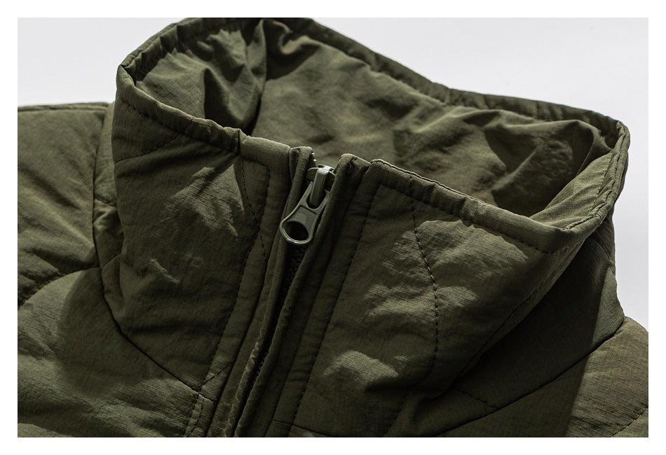 Close-up of an olive-green jacket's padded stand collar and front zipper.