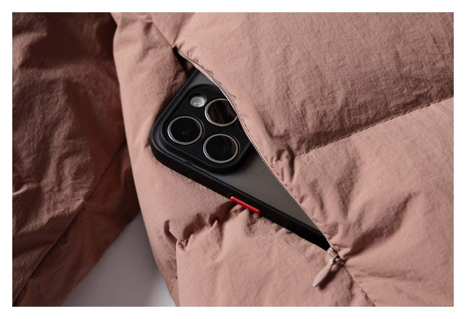 Close-up of a zippered pocket on a dusty rose jacket, with a phone tucked inside.
