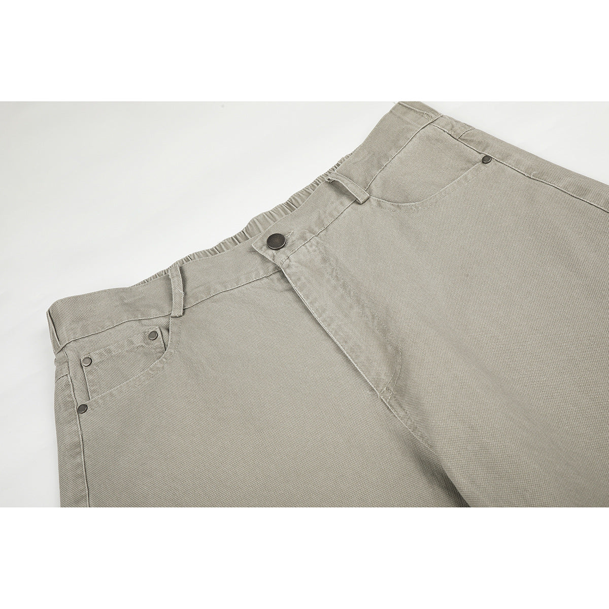 Close-up of light gray-beige pants showing the waistband, belt loops, front button, fly, and pockets.