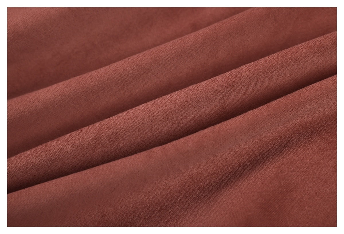 Macro view of rust-brown garment fabric arranged in soft folds.