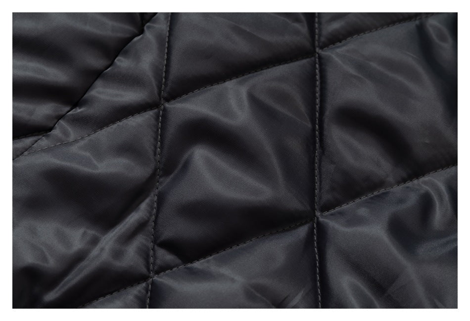 Close-up of dark charcoal quilted lining with geometric stitched panels.