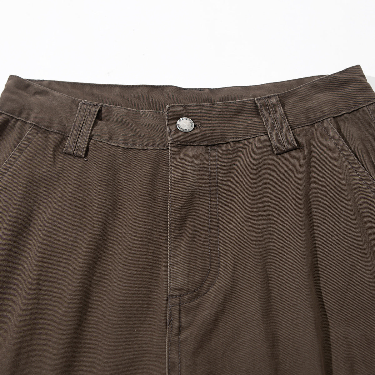 Close-up of brown cargo pants showing the waistband, button, belt loops, and front fly.