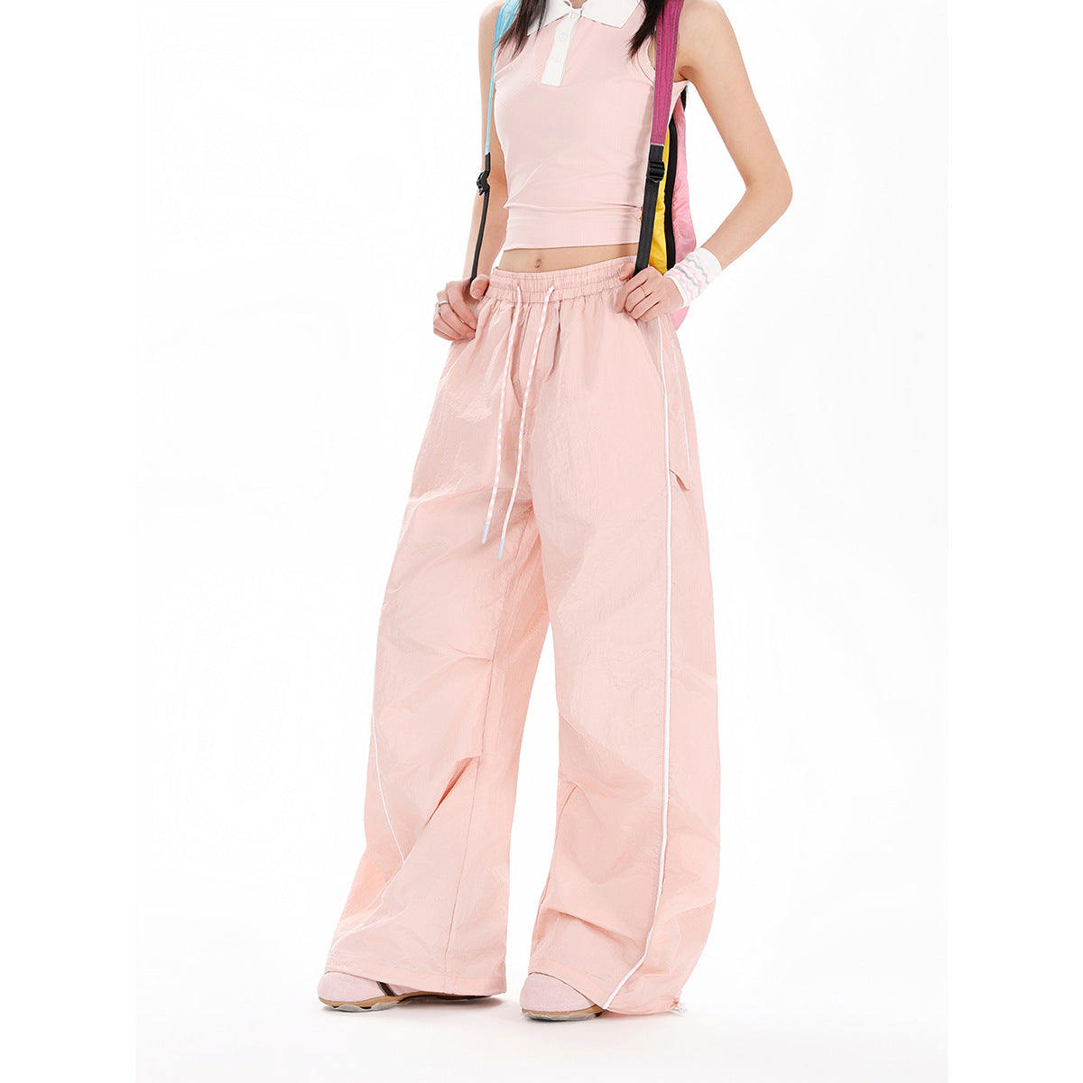 Model wearing pale pink wide-leg pants with an elastic drawstring waist and white side piping.