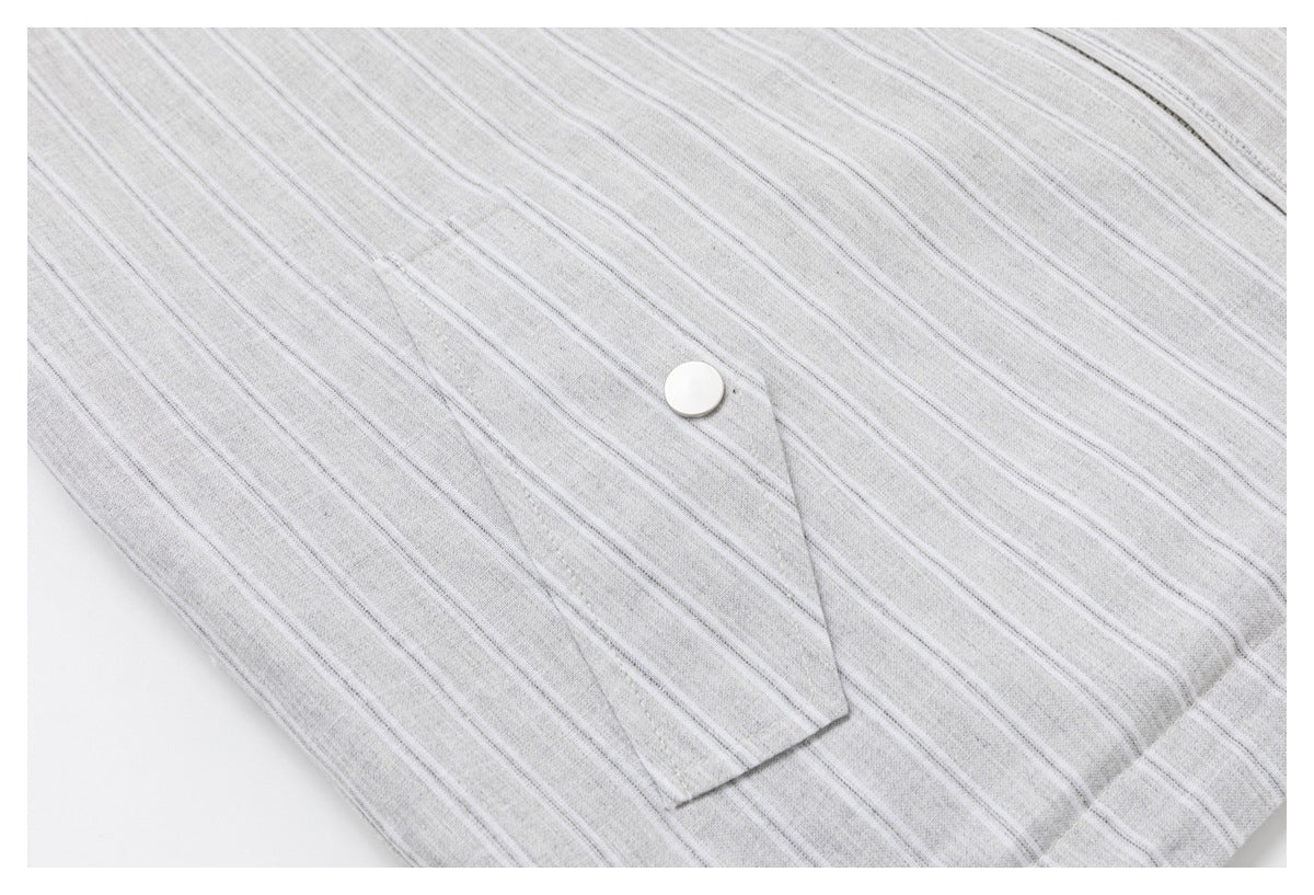 Close-up of a snap-fastened pocket flap on the jacket's light gray striped fabric.
