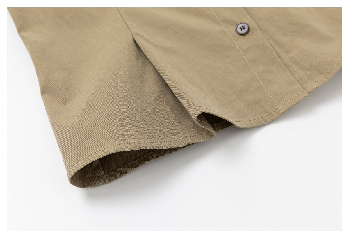 Close-up of the khaki shirt’s curved hem and sleeve edge with a visible button.