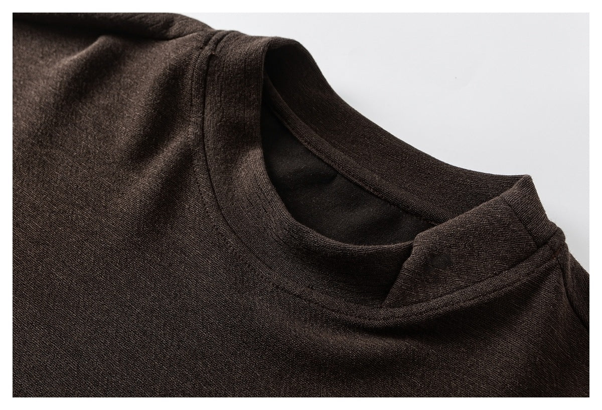 Close-up of a dark brown top showing its rounded neckline, shoulder seam, and knit texture.