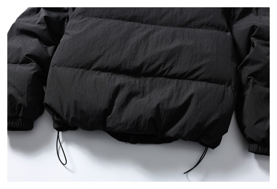 Partial rear view of a black jacket showing horizontal seams, elastic cuffs, and dangling hem drawcords.