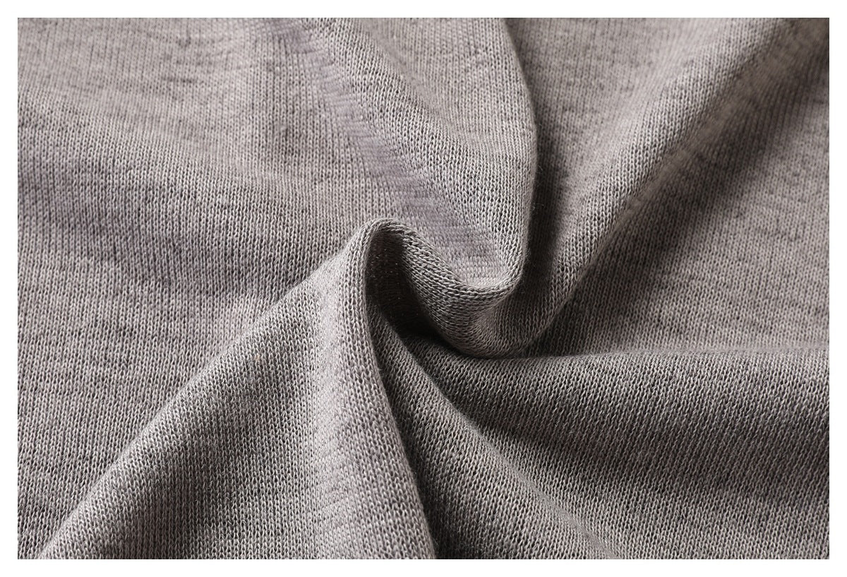 Close-up of heather gray knit fabric gathered into folds, showing its surface texture.