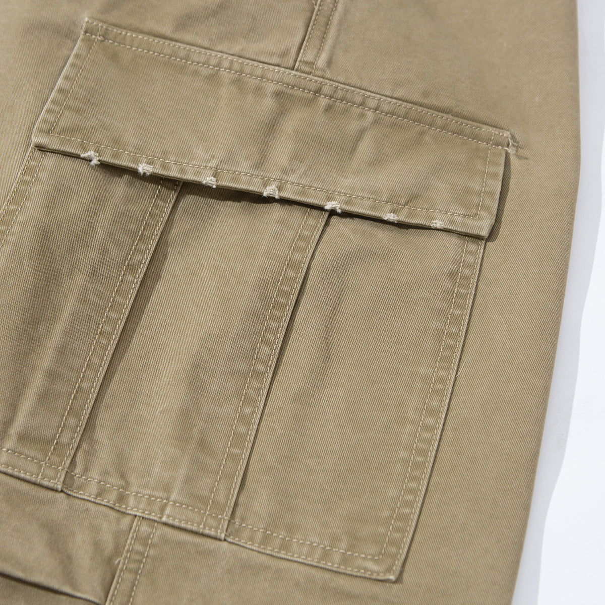 Close-up of a large flap cargo pocket and stitched panels on khaki pants.