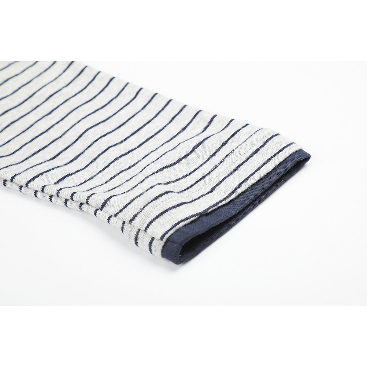 Close-up of a gray shirt sleeve with thin navy stripes and a navy cuff.
