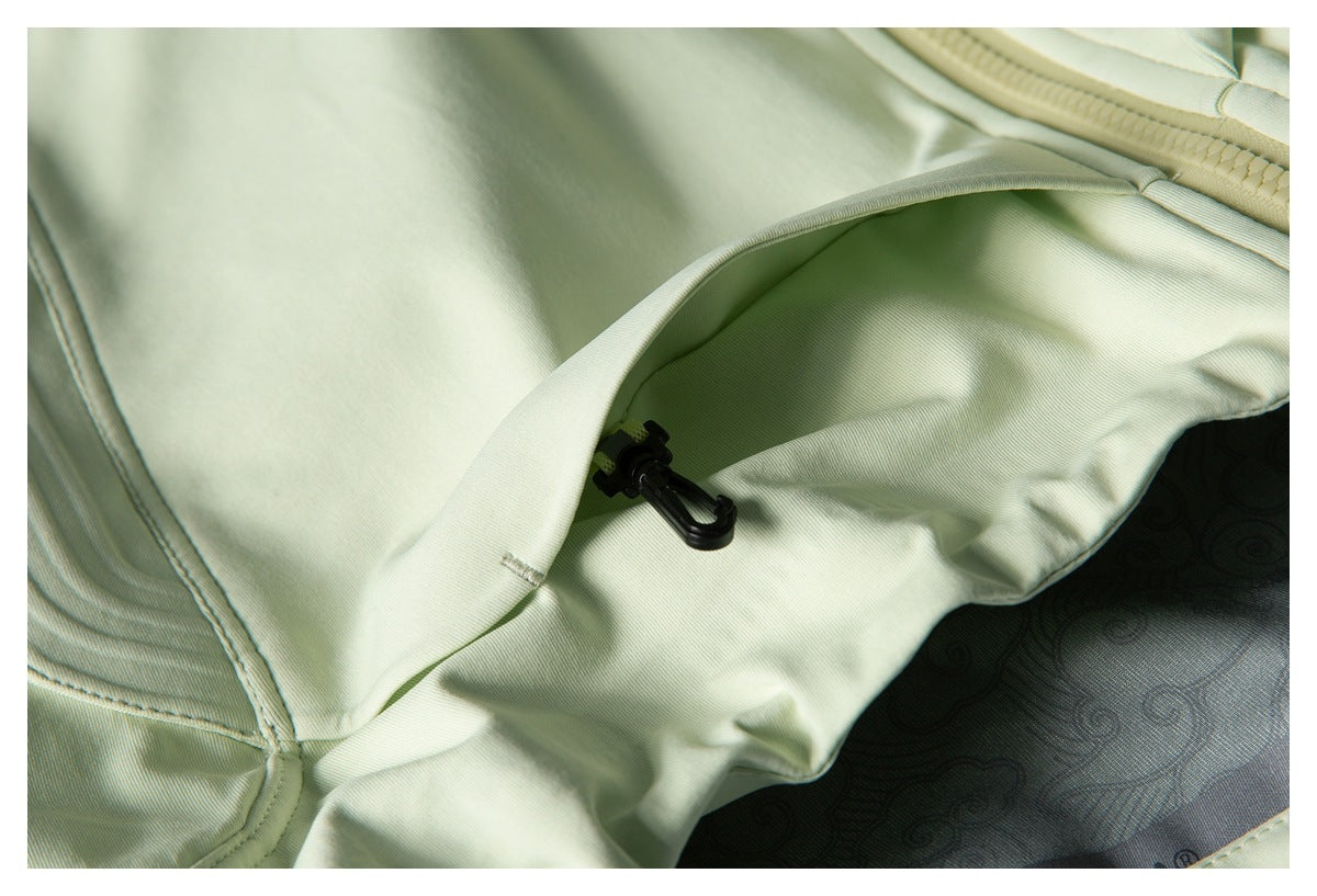 Close-up of the pale sage-green jacket's open inner pocket and a small black plastic clip.