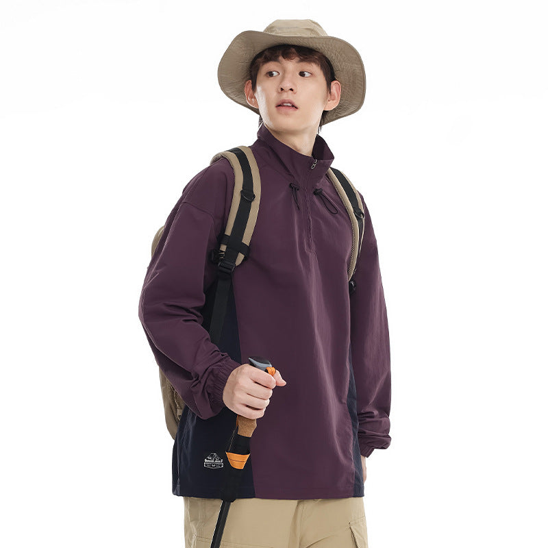 Model wearing a plum pullover with navy side panels, a high collar and drawcords.