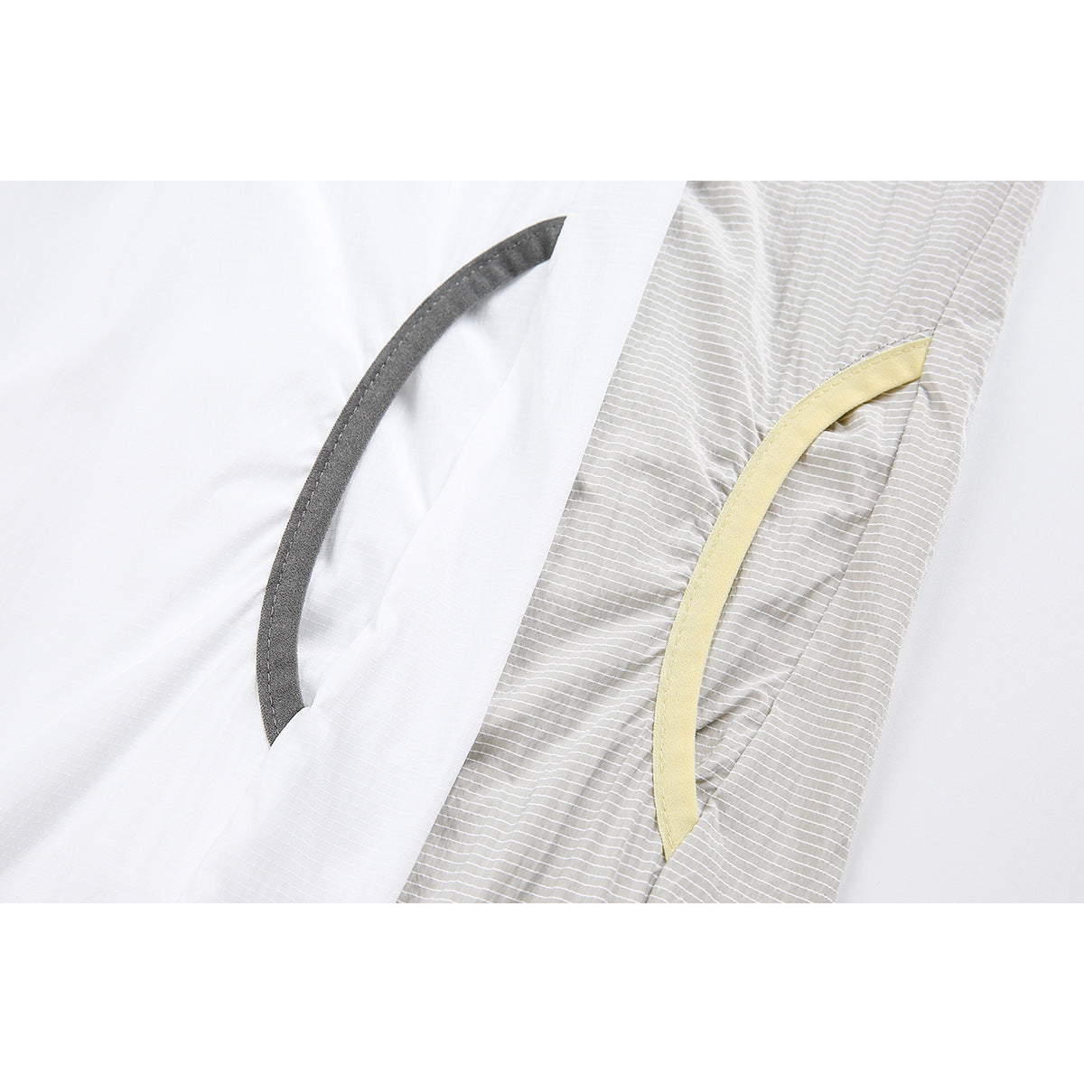 Close-up of curved pockets on white and light gray striped jackets, edged in dark gray and pale yellow trim.