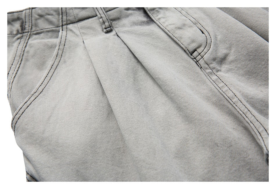 Close-up of the light gray washed denim shorts waistband, belt loops and front seams.