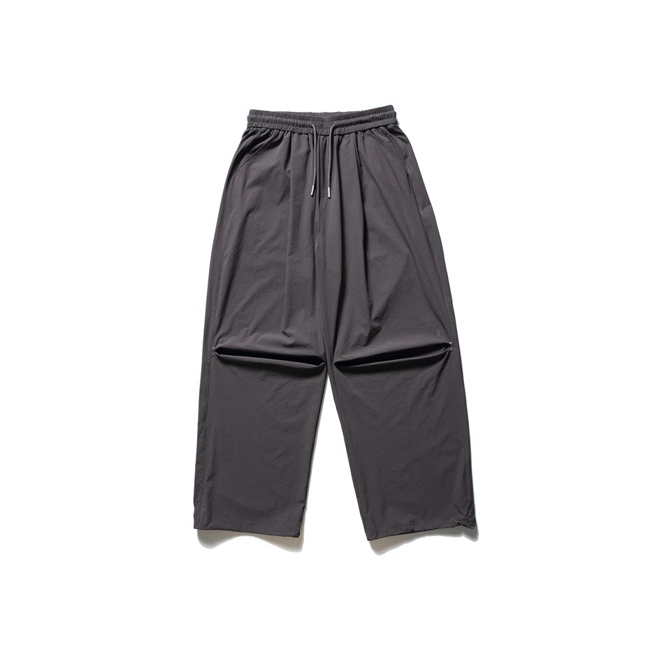 Gray wide-leg drawstring pants with knee pleats, flat lay on a white background