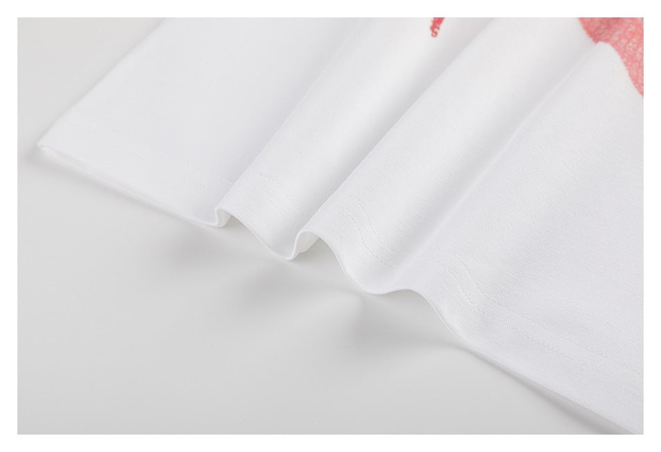 Close-up of the hem of a white shirt with a small portion of red print visible.