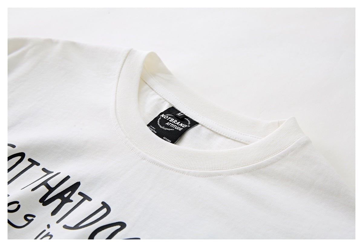 Close-up of an off-white T-shirt collar, neck label, and partially visible black chest print.